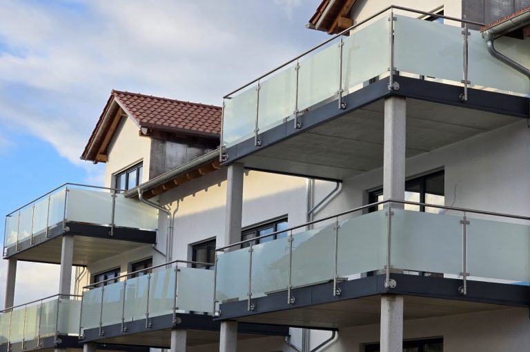 Moderne Wohngebäude mit Balkonen und bruchsicherem Glasgeländer.